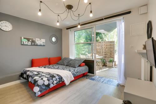 ein Schlafzimmer mit einem Bett und einem großen Fenster in der Unterkunft Appart-hôtel64 Bayonne in Bayonne