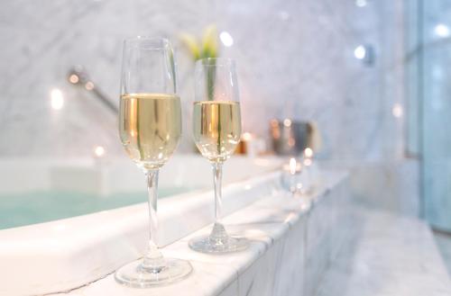 two glasses of champagne sitting on a bath tub at Delfines Hotel & Convention Center in Lima