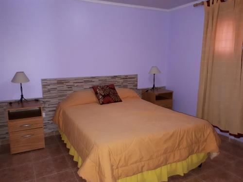a bedroom with a bed and a brick wall at Departamentos San Expedito in Malargüe