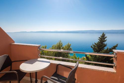 uma varanda com mesa e cadeiras e vista para a água em Adriatic Blue Apartments em Lokva Rogoznica