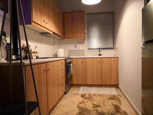 a kitchen with wooden cabinets and a rug on the floor at Luxury Home in Spáta
