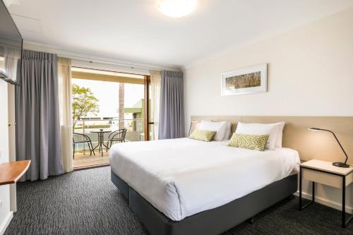 um quarto de hotel com uma cama e uma varanda em Nightcap at the Ship Inn em Busselton