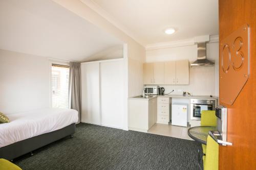 a hotel room with a bed and a kitchen at Nightcap at the Ship Inn in Busselton