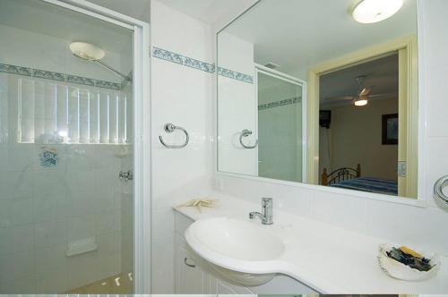 a white bathroom with a sink and a shower at Mirage 602 in Tuncurry