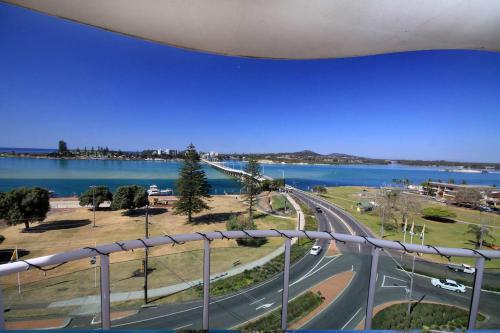 a view from a balcony of a road and water at Mirage 602 in Tuncurry