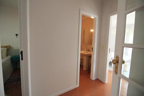 um corredor com uma casa de banho com um lavatório e uma porta em Cabedelo Spot - Beachside Vacations em Viana do Castelo