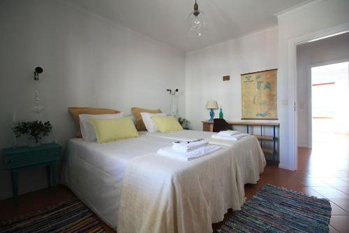 a bedroom with two beds with white sheets and yellow pillows at Cabedelo Spot - Beachside Vacations in Viana do Castelo