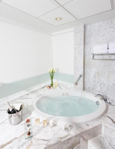 a bathroom with a large tub in a room at Delfines Hotel & Convention Center in Lima
