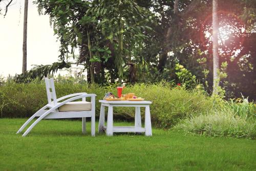 a table and a chair sitting in the grass at The Hidden Paradise Ubud - CHSE Certified in Ubud