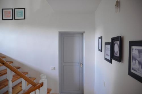 a hallway with a white door and pictures on the wall at SAKÀ Vacation House in Druskininkai
