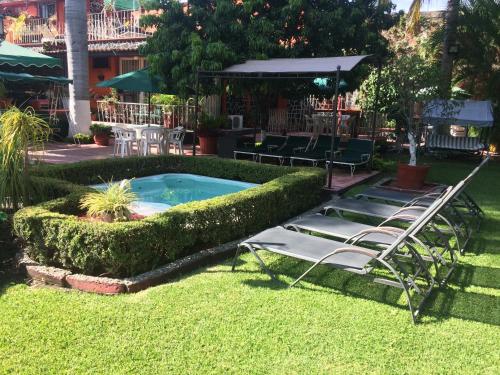 a group of lawn chairs and a swimming pool at Villa Paraiso in Emiliano Zapata