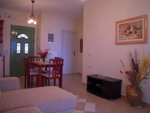 een woonkamer met een bank en een tafel met stoelen bij Villa Pepy in Mesongi
