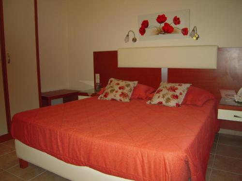 a bedroom with a red bed with two pillows at Villa Pepy in Mesongi
