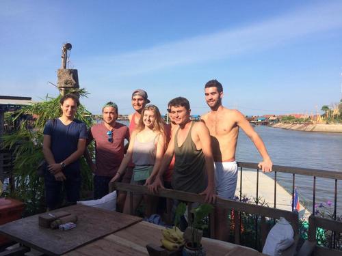 a group of people standing on a fence near the water at ST 63 Home Stay & Tour Kampong Khleang in Kâmpóng Khleăng