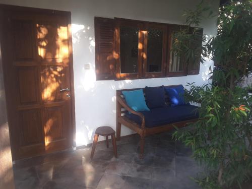 a blue couch sitting in the corner of a room at Si Pitung Village in Gili Air