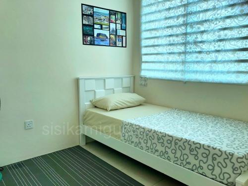 a small bedroom with a bed and a window at Sisikami Guesthouse in Changlun