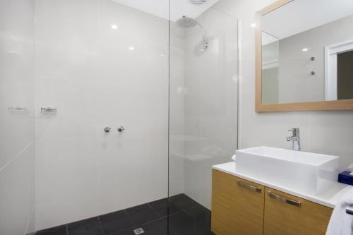 a bathroom with a sink and a shower at Mid City Motel Warrnambool in Warrnambool