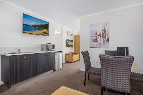 a kitchen with a sink and a table and chairs at Mid City Motel Warrnambool in Warrnambool