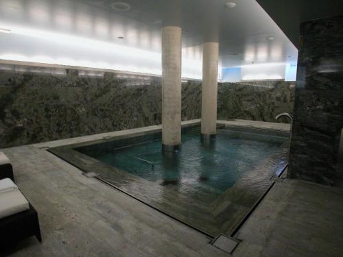 a swimming pool with two columns in a building at Gran Hotel – Balneario de Panticosa in Panticosa