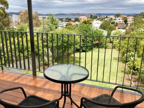 a table and chairs on a balcony with a view at Omaroo House - panoramic water views in Hobart