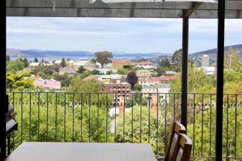 a view from a balcony with a table and chairs at Omaroo House - panoramic water views in Hobart