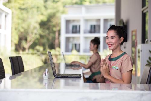 a woman sitting at a table with a laptop at Koh Chang Paradise Hill in Ko Chang