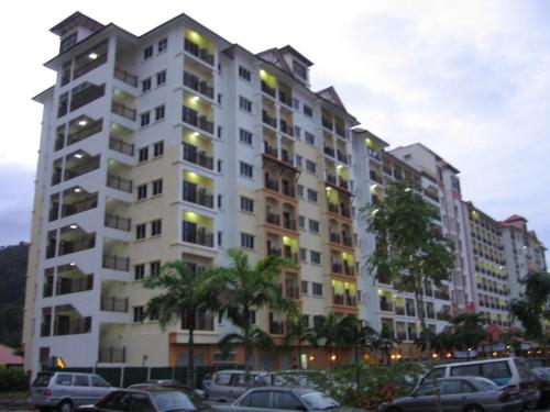 a large white building with cars parked in a parking lot at Bukit Merah 99 Motel(Suria Apartment) in Kampong Selemat
