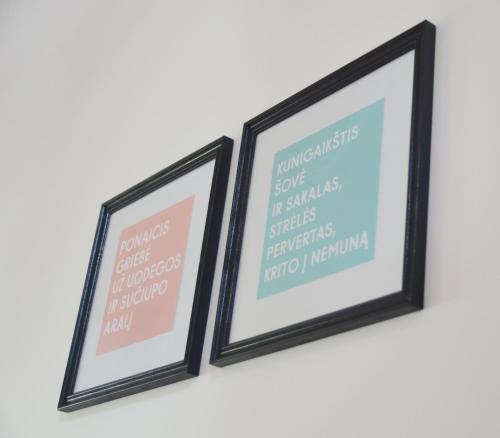 a pair of framed posters on a wall at SAKÀ Vacation House in Druskininkai
