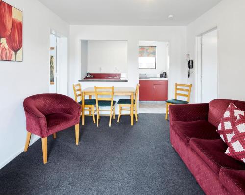 a living room with a couch and a table and chairs at Aotea Motel in Christchurch