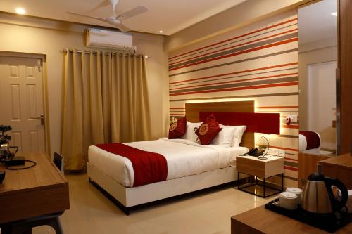 a hotel room with a bed and a desk at Noor jehan's Grand Noor in Palakkad