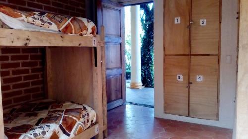 a bedroom with a bunk bed and a brick wall at Rossco Hostel & Hotel in San Cristóbal de Las Casas