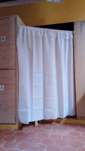 a white curtain in a room next to a dresser at Rossco Hostel & Hotel in San Cristóbal de Las Casas