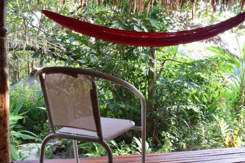 a chair sitting on a porch with a hammock at Rabbit Bungalow in Ko Phayam