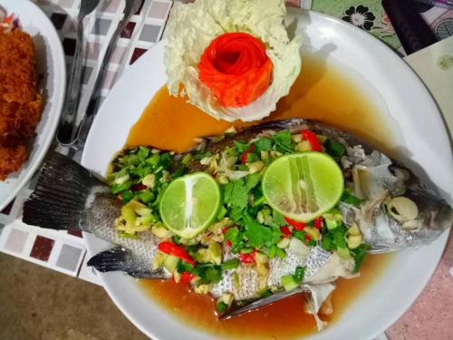 a plate of food with a fish in a bowl of soup at Good Morning Bungalow in Ko Jum