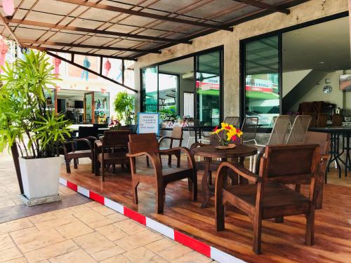 a restaurant with wooden chairs and tables and windows at Baan Sang Singh in Chiang Mai