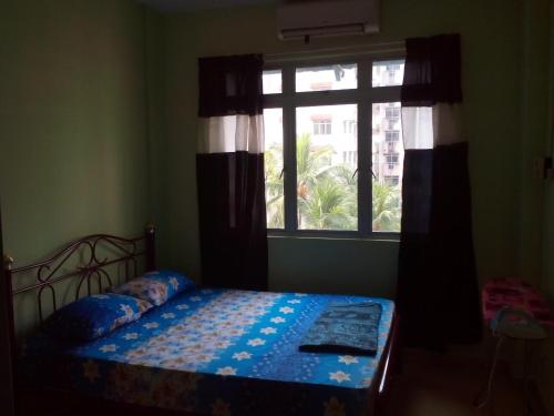 a bedroom with a bed in front of a window at Haji Din Cocobay Condo in Port Dickson