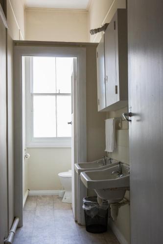 a bathroom with a sink and a toilet and a window at Post Office Hotel in Foxton