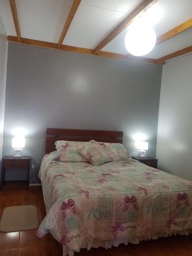 a bedroom with a bed with two lamps on both sides at Departamento Luna Andina in San Pedro de Atacama