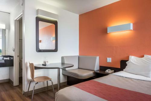 a hotel room with a bed and a table and a mirror at Motel 6-Connellys Springs, NC in Hickory