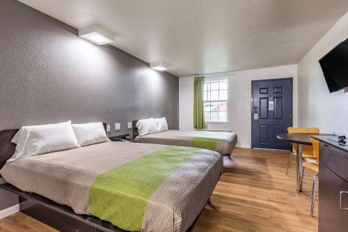 a hotel room with two beds and a flat screen tv at Studio 6-Temple, TX in Temple