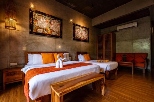 a bedroom with two beds with a dog sitting on the bed at Ipoh Bali Hotel in Ipoh