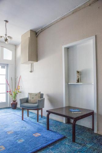 a living room with a table and a chair at Post Office Hotel in Foxton