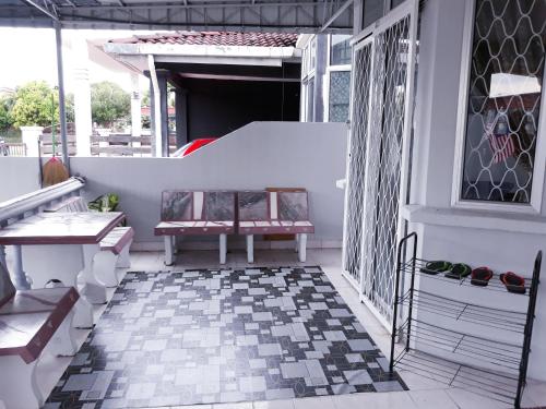 eine Veranda mit einer Bank auf einem Haus in der Unterkunft TSA Jitra Homestay in Kampong Pantai Halban