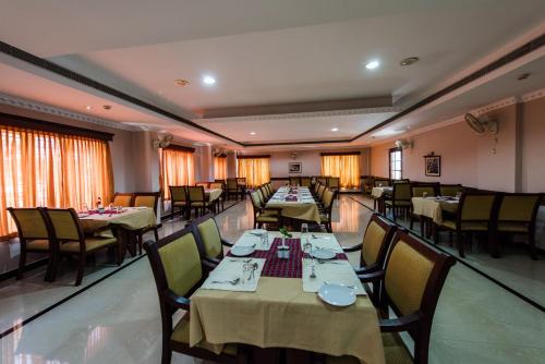 a dining room with tables and chairs in a restaurant at Kallada Hotels and Resorts in Trichūr