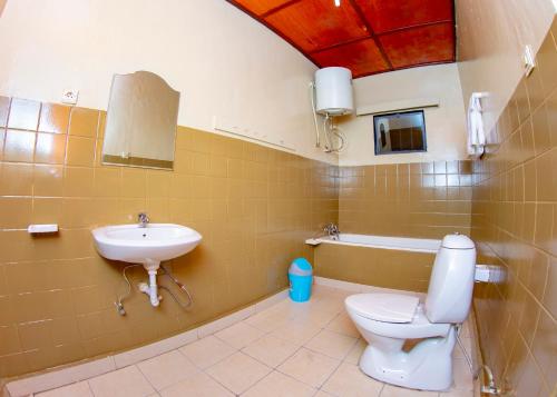 La salle de bains est pourvue de toilettes et d'un lavabo. dans l'établissement B.Maurice Guest House, à Kigali