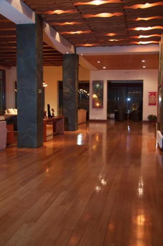 a large lobby with a wooden floor and columns at Gran Hotel Vicente Costanera in Puerto Montt