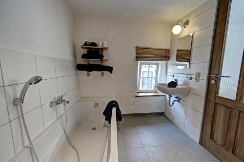 a bathroom with a bath tub and a sink at Ferienhaus Ehrenpreis in Wißmannsdorf