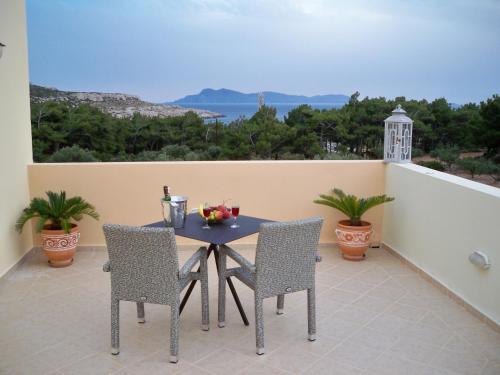 a table and chairs on a balcony with a view at Miraluna Aparthotel in Lefkos Karpathou