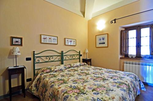a bedroom with a bed with a floral bedspread at Casa Vacanze Le Muse Sillico in Pieve Fosciana