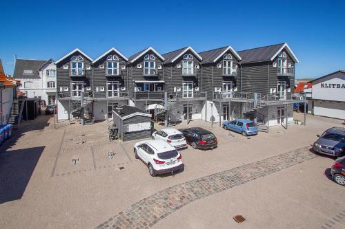 a large building with cars parked in a parking lot at Luksus i Løkken in Løkken